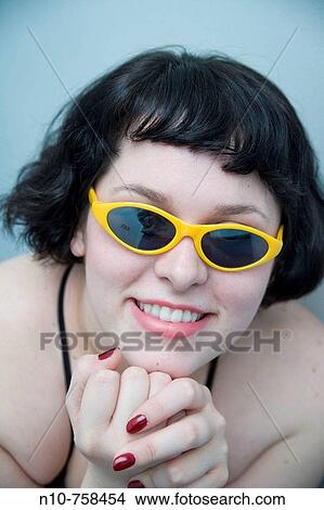 Close-up of a young woman wearing sunglasses. View Large Photo Image Picture - Close-up of a young woman wearing sunglasses.. Fotosearch