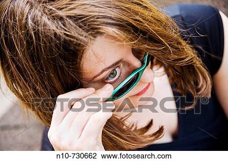 Stock Image - Close-up of a young woman wearing sunglasses.. Fotosearch