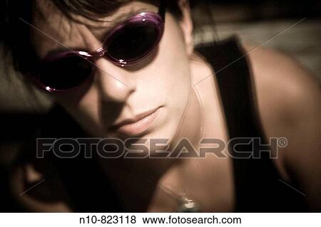 Stock Photo - Close-up of a young woman wearing sunglasses.. Fotosearch