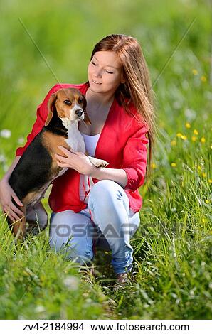 Close-up of a young woman with her Beagle dog in spring. View Large Photo Image Picture - Close-up of a young woman with her Beagle dog in spring.. Fotosearch