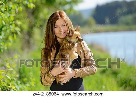 Close-up of a young woman with her Chihuahua dog in spring. View Large Photo Image Picture - Close-up of a young woman with her Chihuahua dog in spring.. Fotosearch