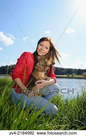 Close-up of a young woman with her Chihuahua dog in spring. View Large Photo Image Stock Image - Close-up of a young woman with her Chihuahua dog in spring.. Fotosearch