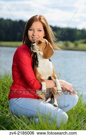 Stock Photograph - Close-up of a young woman with her Beagle dog in spring.. Fotosearch
