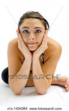 Close up of attractive girl next door posing while seated on the floor with hands framing her face and elbows touching the floor. View Large Photo Image Picture - Close up of attractive girl next door posing while seated on the floor with hands framing her face and elbows touching the floor.. Fotosearch
