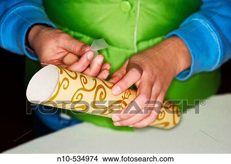 Close-up of hands putting tape onto a wrapped present View Large Photo Image Picture - Close-up of hands putting tape onto a wrapped present. Fotosearch