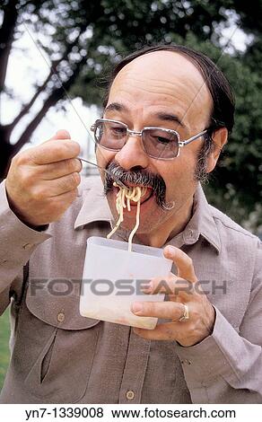 close up of Italian man eating spaghetti from plastic container View Large Photo Image Stock Photo - close up of Italian man eating spaghetti from plastic container. Fotosearch