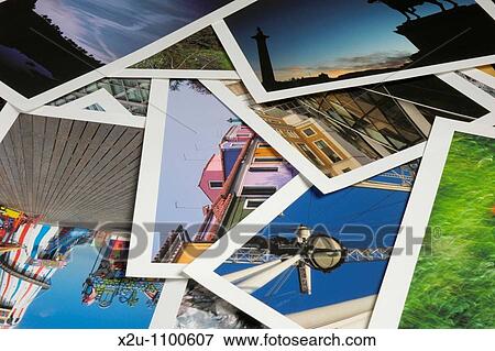 Stock Photo - Close-up of numerous overlapping colourful A4 photographic prints with white borders. Fotosearch