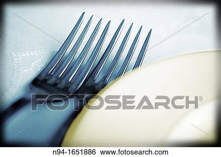 Stock Photograph - Close up of plate and cutlery on the table ready for lunch.. Fotosearch