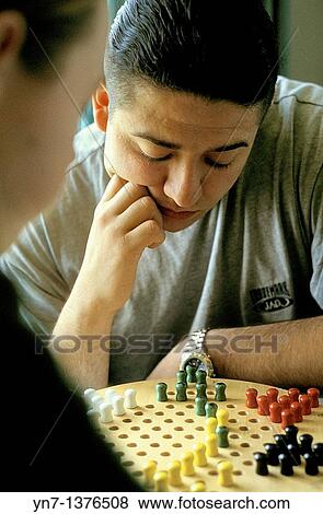 close up of player as he ponders his next move on the chinese chequers board View Large Photo Image Stock Photo - close up of player as he ponders his next move on the chinese chequers board. Fotosearch