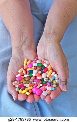 Close up of Senior womann holding a handful of colored pills and capsules in her hands, sitting on her bed in her bedroom View Large Photo Image Stock Photography - Close up of Senior womann holding a handful of colored pills and capsules in her hands, sitting on her bed in her bedroom. Fotosearch