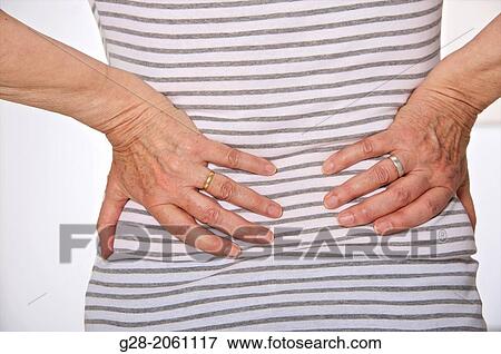 Close up of senior woman's hands holding waist and back, suffering from backache, seen from behind View Large Photo Image Stock Photo - Close up of senior woman's hands holding waist and back, suffering from backache, seen from behind. Fotosearch