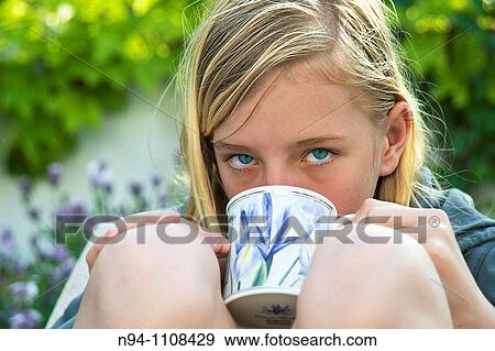 Stock Photo - Close up of teenage girl with a cup of soup in the garden.. Fotosearch