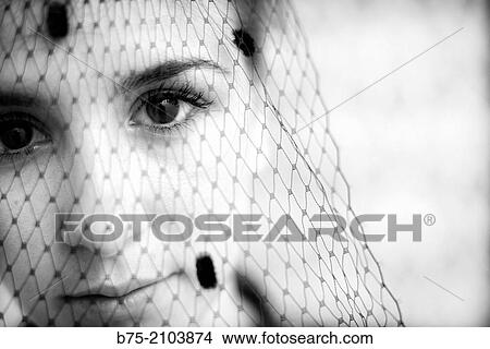 Close-up of teenager girl looking at the camera with a veil in front of her face. View Large Photo Image Picture - Close-up of teenager girl looking at the camera with a veil in front of her face.. Fotosearch