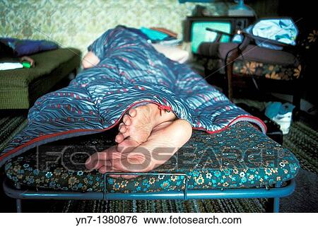 close up of the bare feet of a sleeper in a camp bed in the spare room View Large Photo Image Stock Photograph - close up of the bare feet of a sleeper in a camp bed in the spare room. Fotosearch