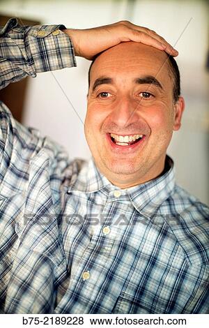 Close-up of the face of a 40-year-old Caucasian man, smiling and positive attitude, with one hand on his head and wearing plaid shirt. View Large Photo Image Stock Photo - Close-up of the face of a 40-year-old Caucasian man, smiling and positive attitude, with one hand on his head and wearing plaid shirt.. Fotosearch