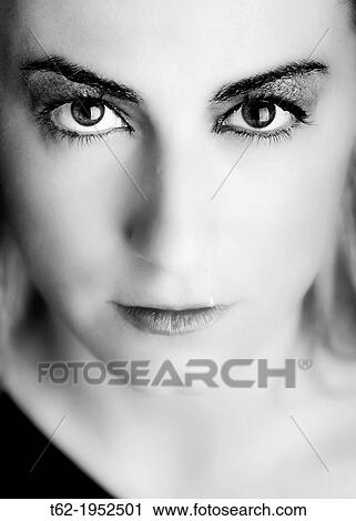 Stock Image - Close up of the face of a young woman with tears in her eyes.. Fotosearch