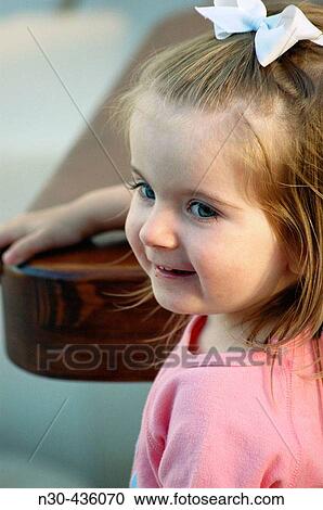 Stock Image - Close up of Toddler Girl sitting at table. Fotosearch