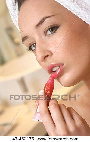 Close up of woman about apply red lipgloss serious expression View Large Photo Image Stock Photograph - Close up of woman about apply red lipgloss serious expression. Fotosearch