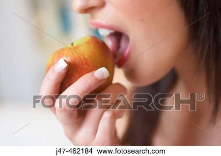 Close up of woman about to bite into an apple View Large Photo Image Picture - Close up of woman about to bite into an apple. Fotosearch