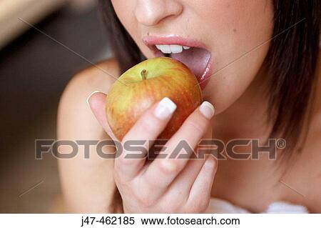 Close up of woman about to bite into an apple View Large Photo Image Stock Photography - Close up of woman about to bite into an apple. Fotosearch