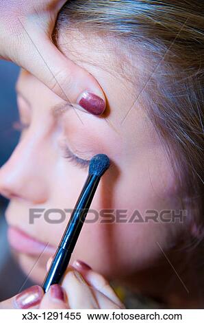 Stock Photography - Close-up of woman getting eyeshadow applied. Fotosearch