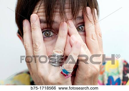 Close-up of woman looking through her fingers View Large Photo Image Stock Photograph - Close-up of woman looking through her fingers. Fotosearch