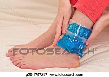 Close up of woman's hands holding a hot or cold blue pouch around her ankle, to treat rheumatism, or a sprained ankle View Large Photo Image Stock Photo - Close up of woman's hands holding a hot or cold blue pouch around her ankle, to treat rheumatism, or a sprained ankle. Fotosearch