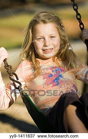 Stock Photo - Close-up of young girl on swing smiling - Franklin Park - Brevard, North Carolina. Fotosearch