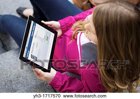 Close up picture of a young woman using Facebook social networking website on an iPad 2 View Large Photo Image Stock Image - Close up picture of a young woman using Facebook social networking website on an iPad 2. Fotosearch