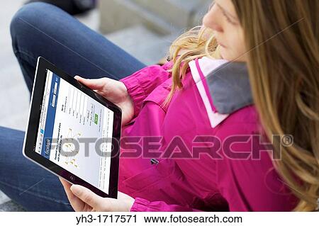 Close up picture of a young woman using Facebook social networking website on an iPad 2 View Large Photo Image Stock Image - Close up picture of a young woman using Facebook social networking website on an iPad 2. Fotosearch
