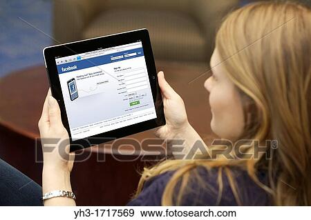 Close up picture of a young woman using Facebook social networking website on an iPad 2 View Large Photo Image Stock Photo - Close up picture of a young woman using Facebook social networking website on an iPad 2. Fotosearch