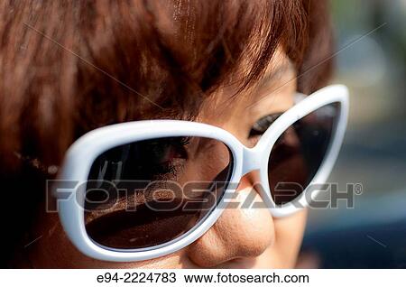 Close up portrait of a 38 year old Asian-American woman wearing white rimmed sunglasses. View Large Photo Image Stock Image - Close up portrait of a 38 year old Asian-American woman wearing white rimmed sunglasses.. Fotosearch