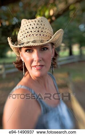 Close up portrait of a 52 year old blonde woman wearing a tank top and a straw hat looking at the camera. View Large Photo Image Stock Photo - Close up portrait of a 52 year old blonde woman wearing a tank top and a straw hat looking at the camera.. Fotosearch