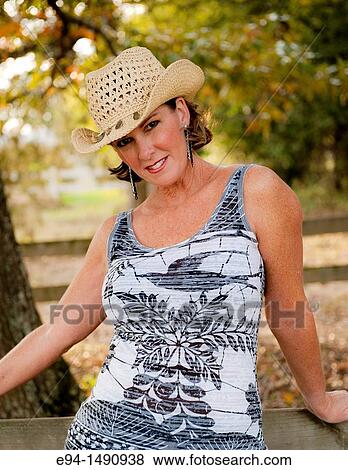 Close up portrait of a 52 year old blonde woman wearing a tank top and a straw hat looking at the camera. View Large Photo Image Stock Photo - Close up portrait of a 52 year old blonde woman wearing a tank top and a straw hat looking at the camera.. Fotosearch