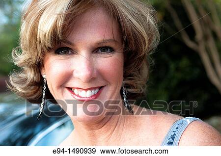 Close up portrait of a 52 year old blonde woman wearing a tank top looking at the camera. View Large Photo Image Stock Photo - Close up portrait of a 52 year old blonde woman wearing a tank top looking at the camera.. Fotosearch