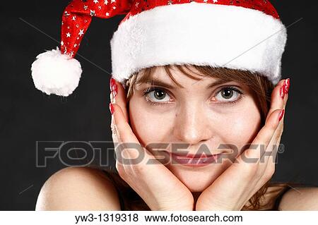 Stock Photo - Close-up portrait of a woman wearing a Christmas hat. Fotosearch