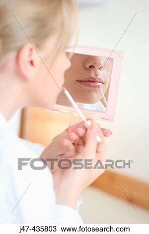 Close up shot of mouth of a girl putting lipstick on in a mirror View Large Photo Image Stock Image - Close up shot of mouth of a girl putting lipstick on in a mirror. Fotosearch