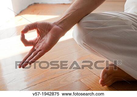Close view of man's hand practicing yoga, sitting in the lotus position. View Large Photo Image Stock Photography - Close view of man's hand practicing yoga, sitting in the lotus position.. Fotosearch
