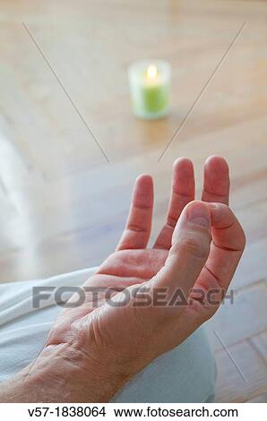 Close view of man's hand practising yoga, sitting in the lotus position View Large Photo Image Picture - Close view of man's hand practising yoga, sitting in the lotus position. Fotosearch