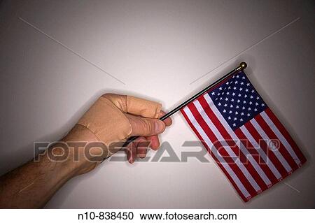 Close_up of a man's bandaged hand holding a small American flag. View Large Photo Image Stock Image - Close_up of a man's bandaged hand holding a small American flag.. Fotosearch