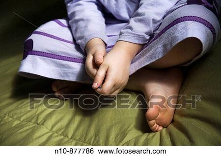 Stock Photograph - Close_up of a young girl on her bed. Model and Property Released.. Fotosearch