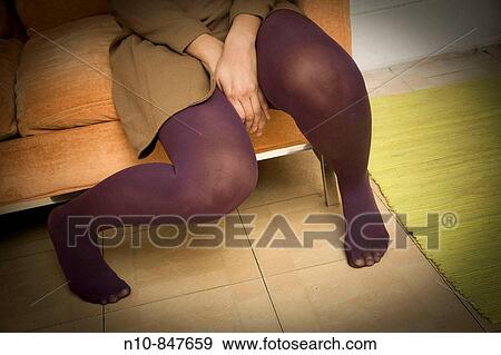 Close_up of a young woman sitting on her sofa. View Large Photo Image Stock Photo - Close_up of a young woman sitting on her sofa.. Fotosearch