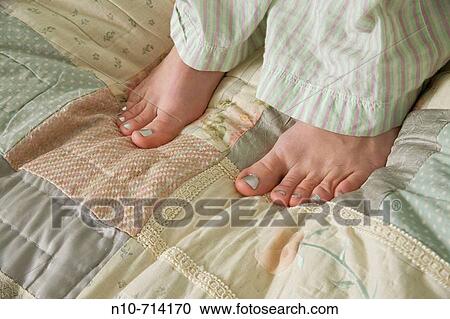 Close_up of a young woman's feet as she stands on her bed. View Large Photo Image Stock Image - Close_up of a young woman's feet as she stands on her bed.. Fotosearch