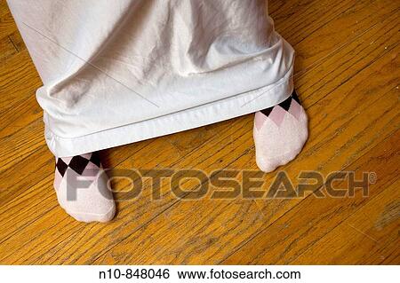 Close_up of a young woman's feet from under her nightgown. View Large Photo Image Stock Photograph - Close_up of a young woman's feet from under her nightgown.. Fotosearch