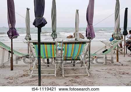 Stock Image - Closed Umbrellas on a emty Beach. Fotosearch