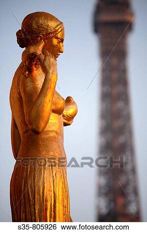 Closed up view of a gilded bronze statues on the central square of the Palais de Chailot with Eiffel Tower in background, Paris. France View Large Photo Image Stock Photograph - Closed up view of a gilded bronze statues on the central square of the Palais de Chailot with Eiffel Tower in background, Paris. France. Fotosearch