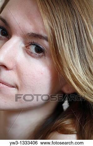 closeup half of face of pretty girl against light wall blank expression View Large Photo Image Stock Photograph - closeup half of face of pretty girl against light wall blank expression. Fotosearch