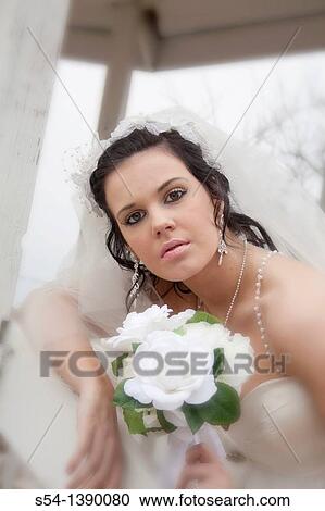 Stock Image - Closeup of a bride holding her bouquet. Fotosearch