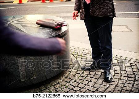 Closeup of a relaxed executive smoking a cigarette with a portfolio on a bench in the city of London, England, UK, Europe View Large Photo Image Stock Photography - Closeup of a relaxed executive smoking a cigarette with a portfolio on a bench in the city of London, England, UK, Europe. Fotosearch