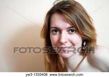Stock Photo - closeup of face of pretty girl against light wall blank expression. Fotosearch